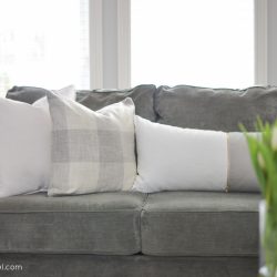 An assortment of grey and white pillows create a soft and inviting atmosphere in this modern farmhouse living room | A Burst of Beautiful