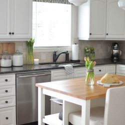 Beautiful white farmhouse kitchen, complete with butch block island, custom cabinetry and schoolhouse pendant lights | A Burst of Beautiful