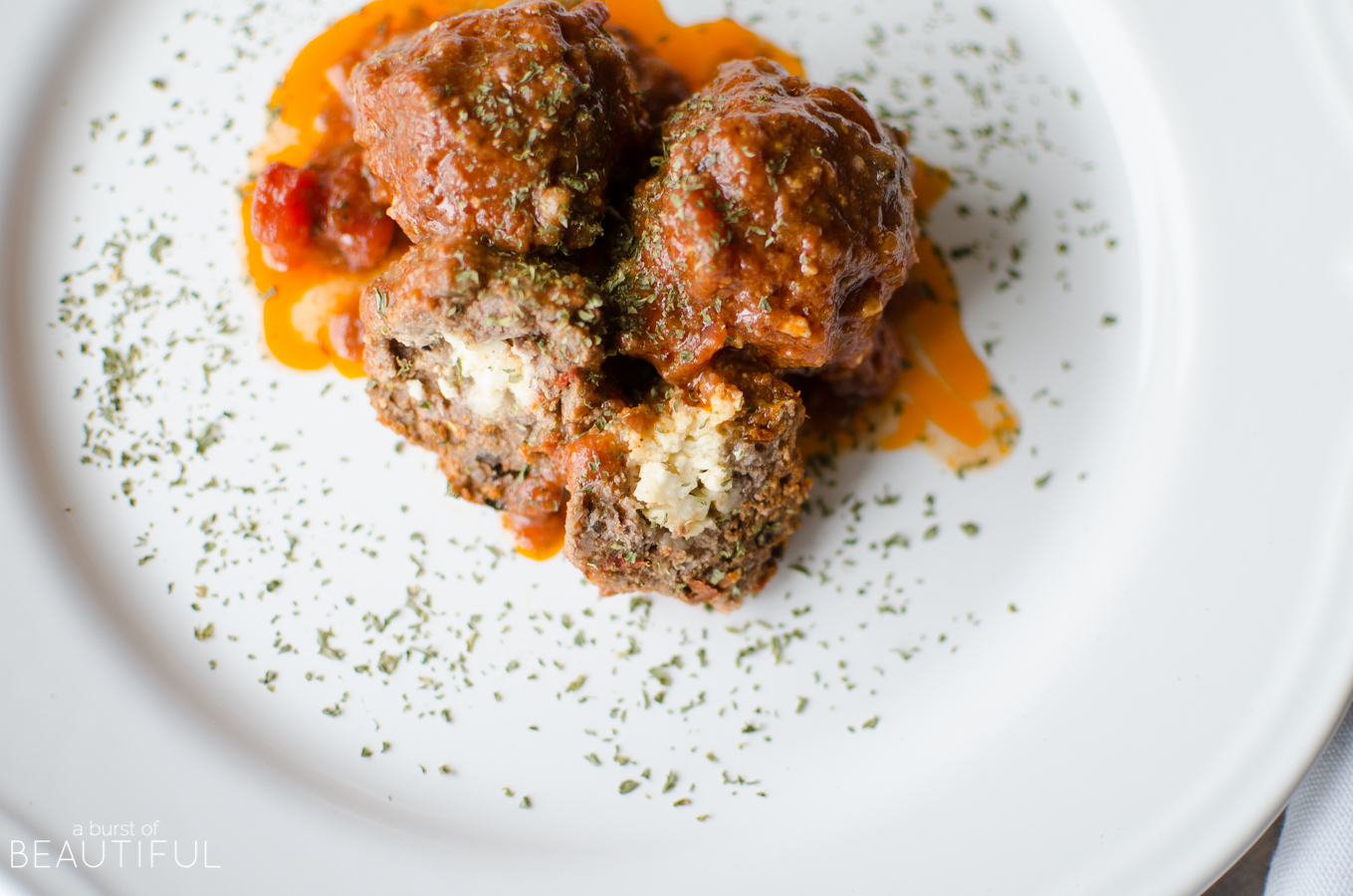 Perfect as an appetizer or served as part of a meal, our Slow Cooker Stuffed Mediterranean Meatballs are stuffed with feta cheese, sundried tomatoes and black olives to create a mouthwatering flavour combination | A Burst of Beautiful 