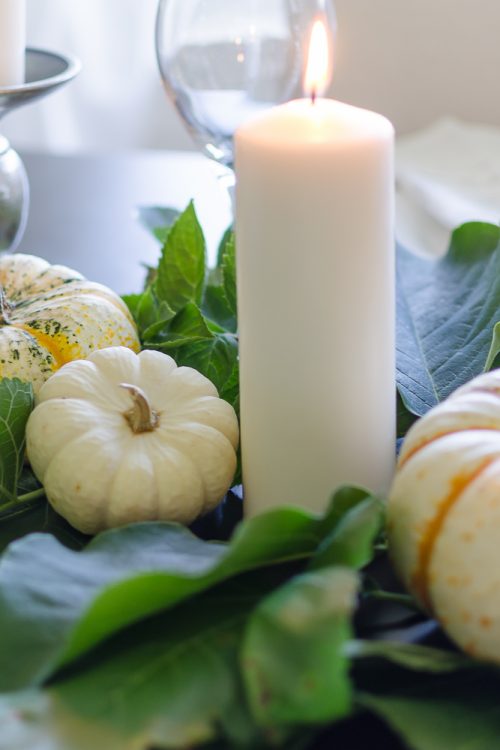Create a simple and classic fall tablescape using mini pumpkins, fresh greenery and candles.