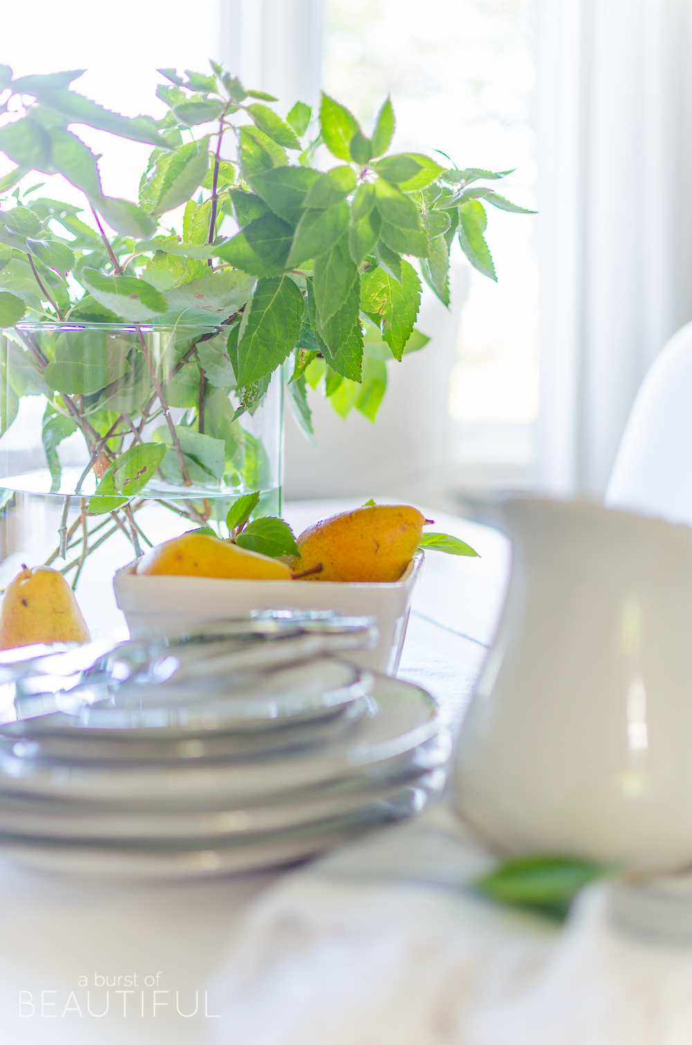 A bright and inviting dining room boasts simple farmhouse style with a DIY farmhouse dining table and classic window bench. 