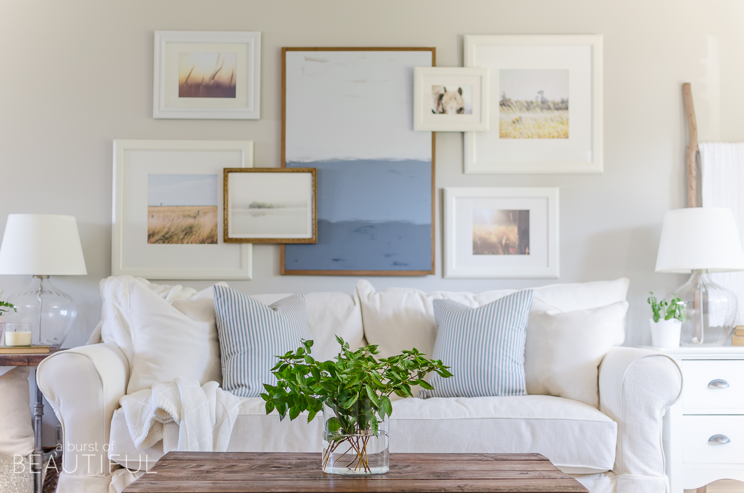 A layered gallery wall adds interest and depth to this charming modern farmhouse living room. 