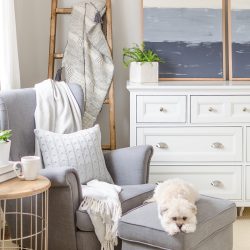 A simple DIY angled blanket ladder adds a touch of farmhouse charm to this cozy bedroom.