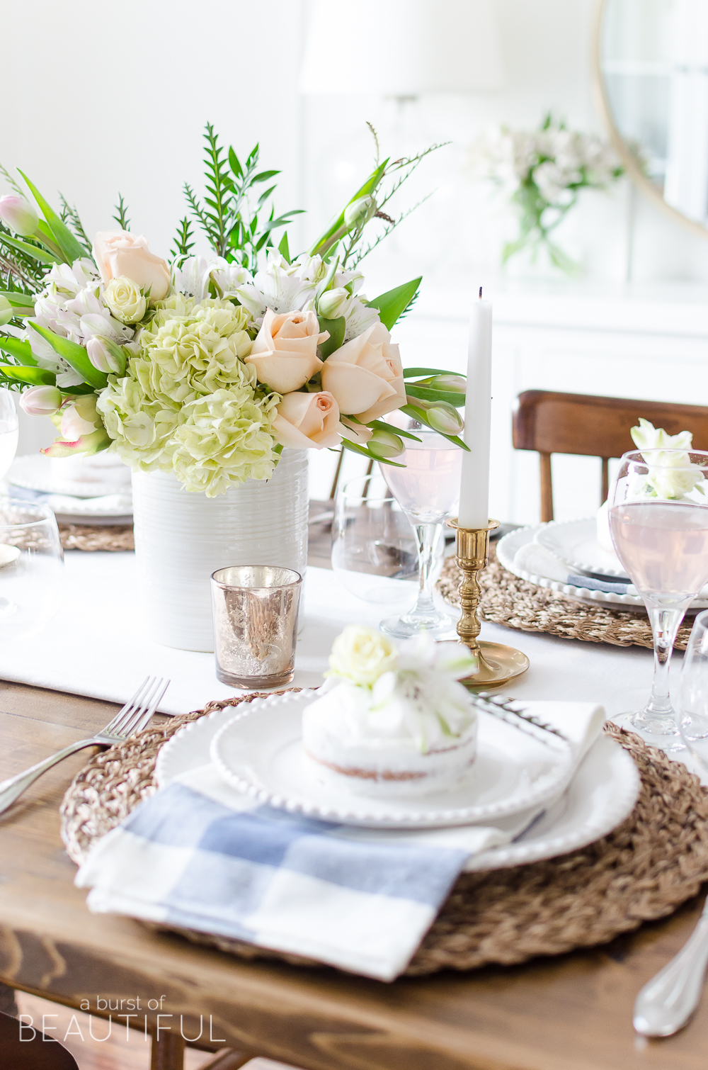 Roses, tulips and hydrangeas create the perfect centerpiece for this simple pink and gold spring tablescape. 