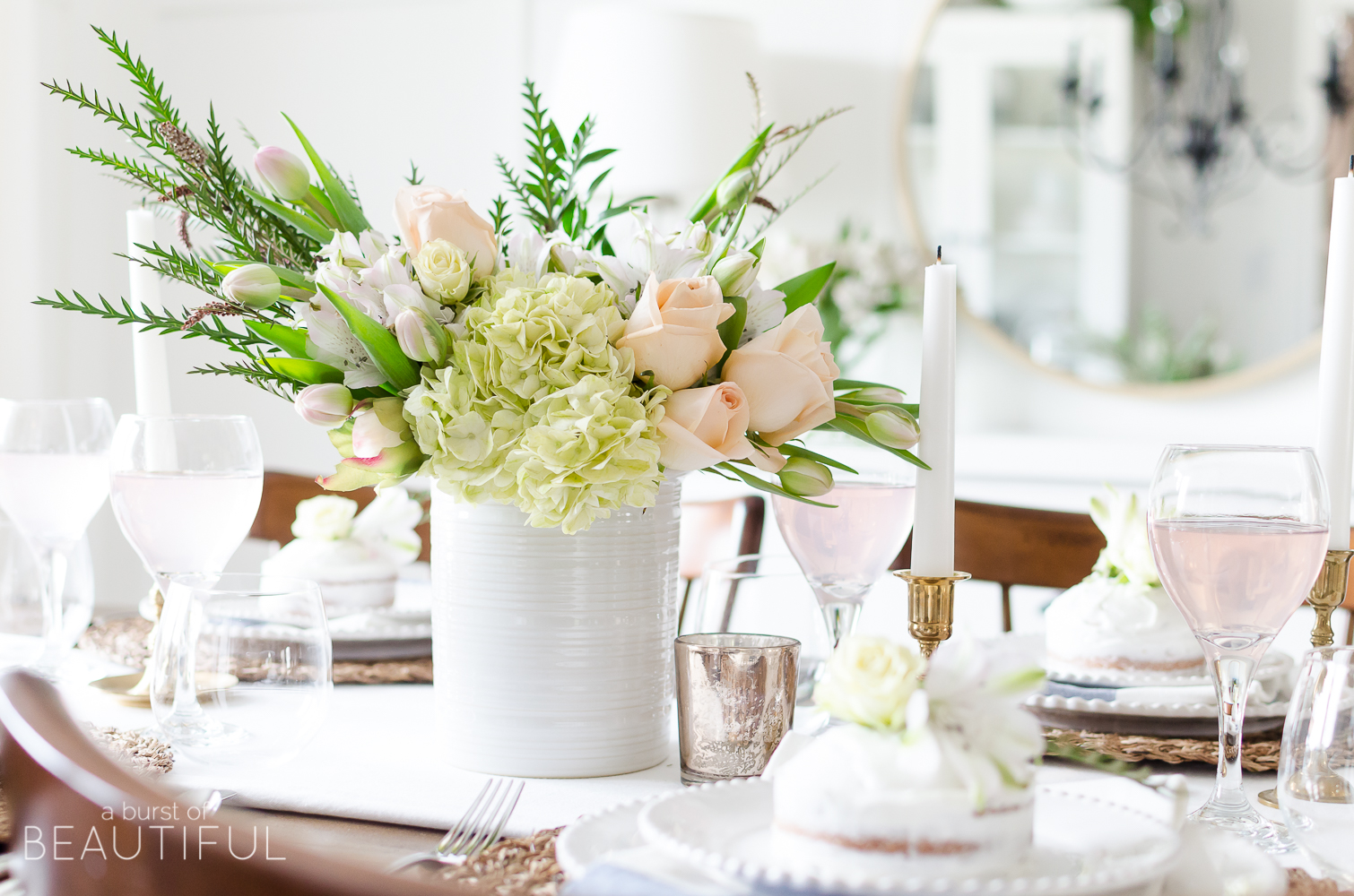 Roses, tulips and hydrangeas create the perfect centerpiece for this simple pink and gold spring tablescape. 