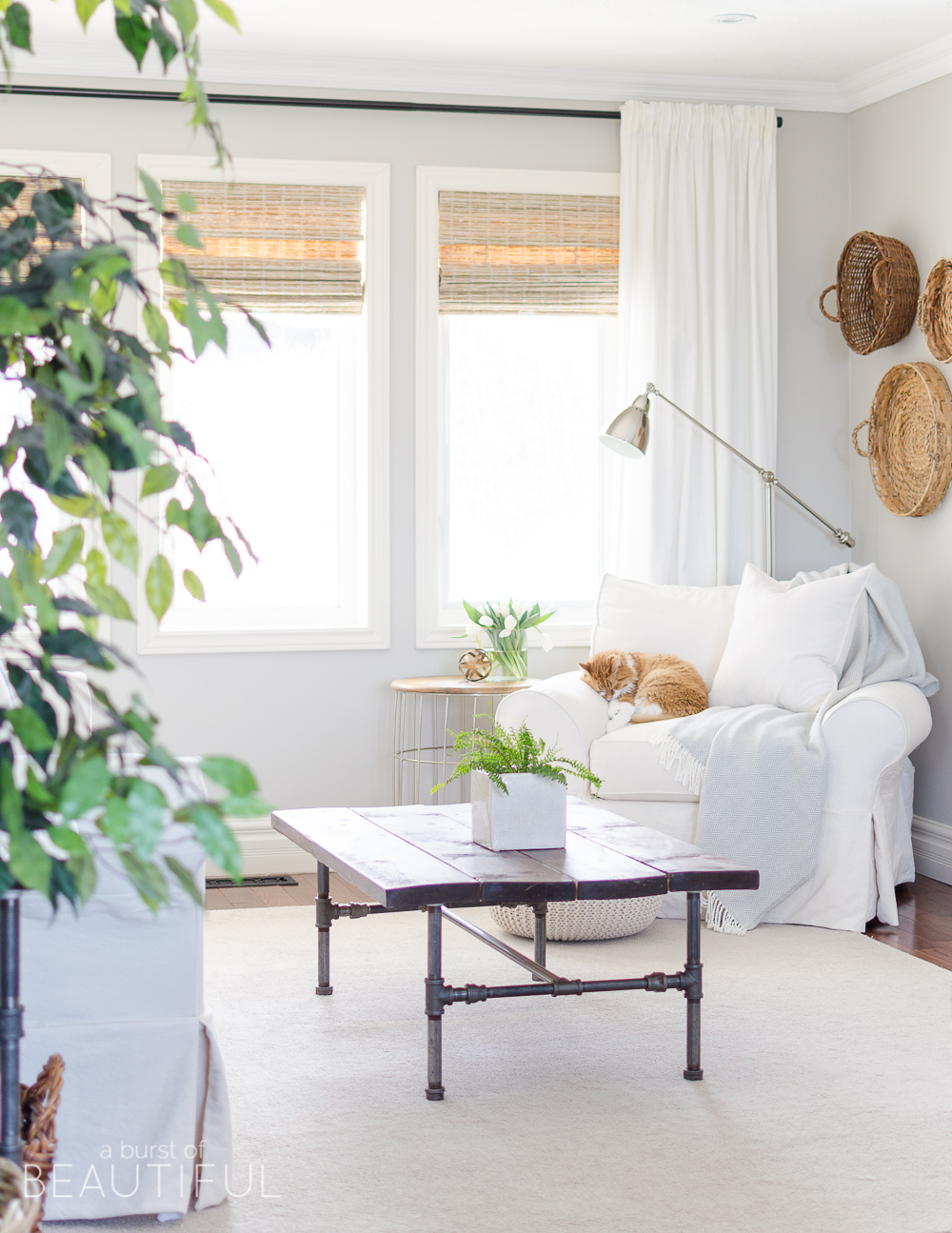 Spring Home Tour | Our Living Room - A modern farmhouse living room looks fresh and cheerful for spring with a subtle blue and white color palette and layered coastal gallery wall. 