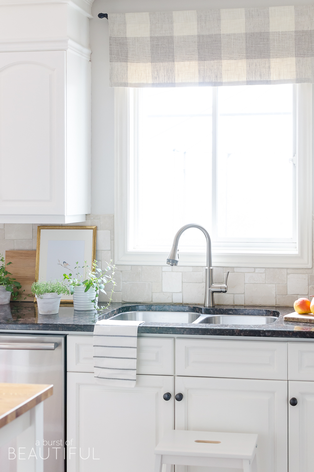 A sleek new pull-down faucet adds a touch of modern simplicity to this white modern farmhouse kitchen. 