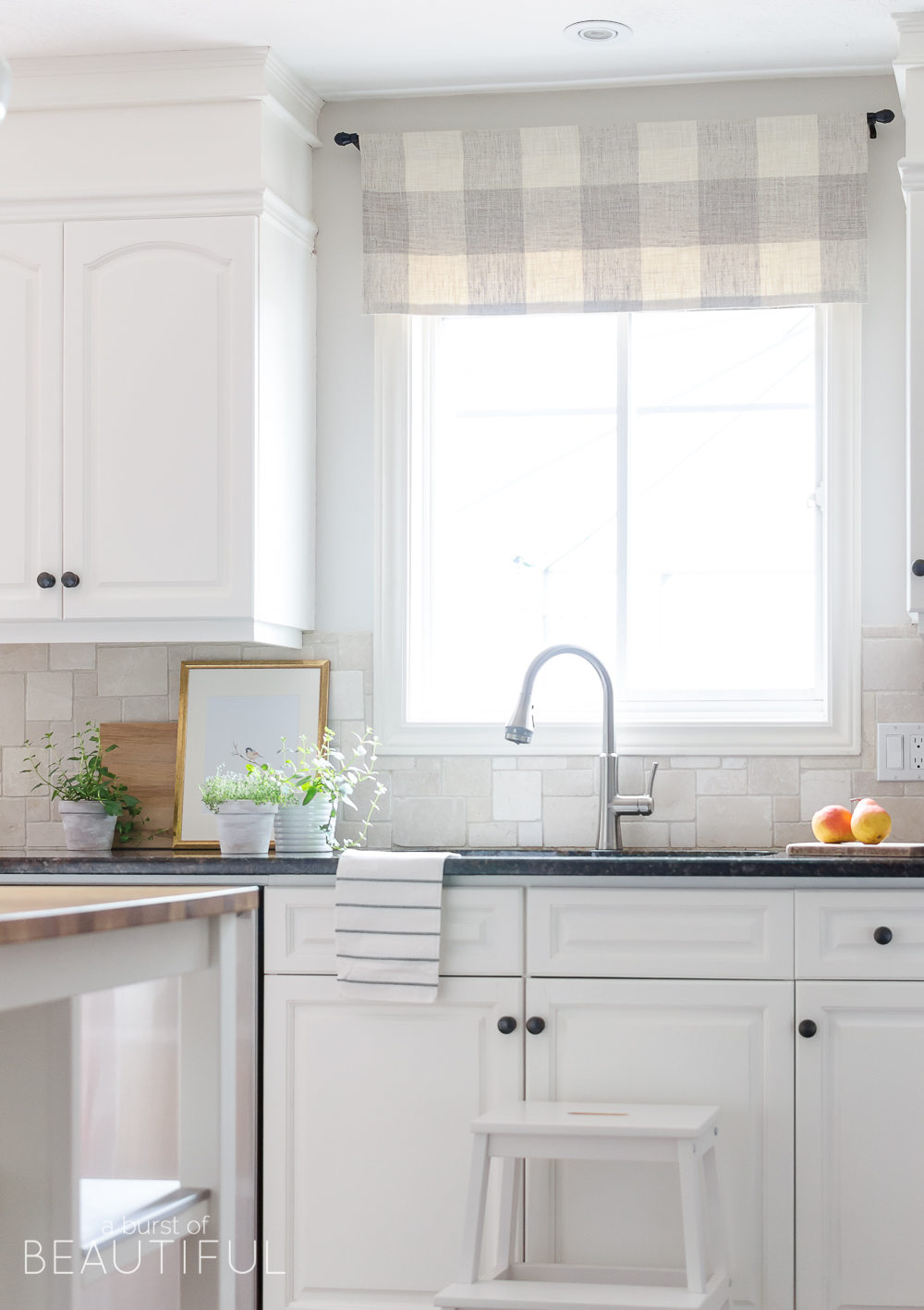 A sleek new pull-down faucet adds a touch of modern simplicity to this white modern farmhouse kitchen. 