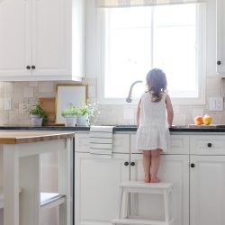 A sleek new pull-down faucet adds a touch of modern simplicity to this white modern farmhouse kitchen.