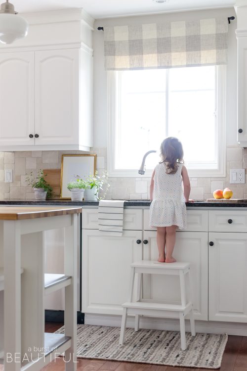 A sleek new pull-down faucet adds a touch of modern simplicity to this white modern farmhouse kitchen.