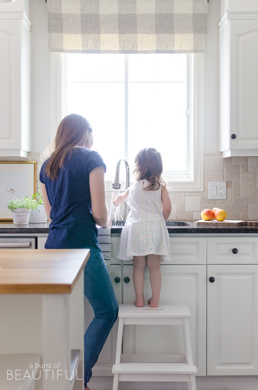 A sleek new pull-down faucet adds a touch of modern simplicity to this white modern farmhouse kitchen. 