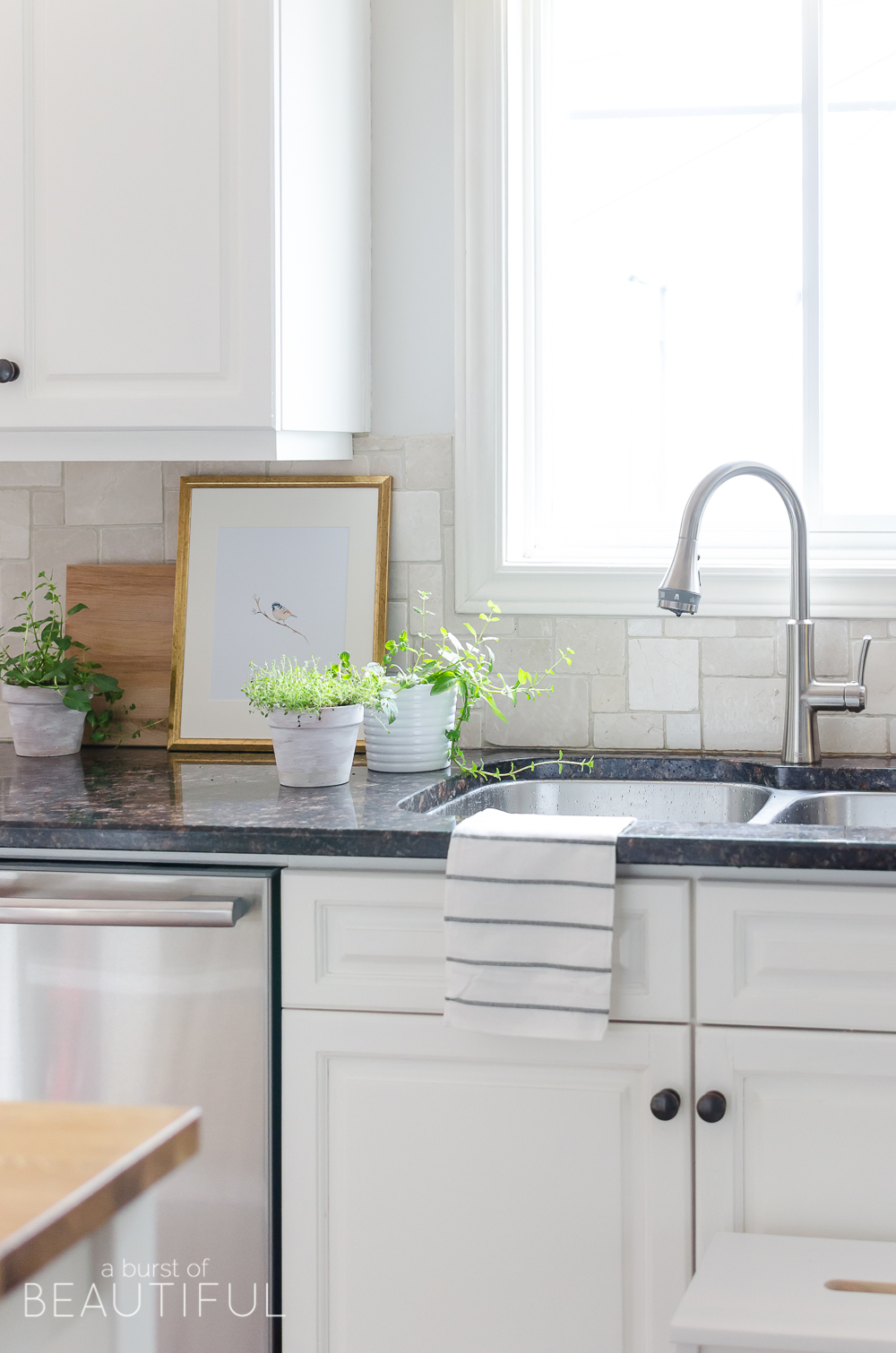 A sleek new pull-down faucet adds a touch of modern simplicity to this white modern farmhouse kitchen. 