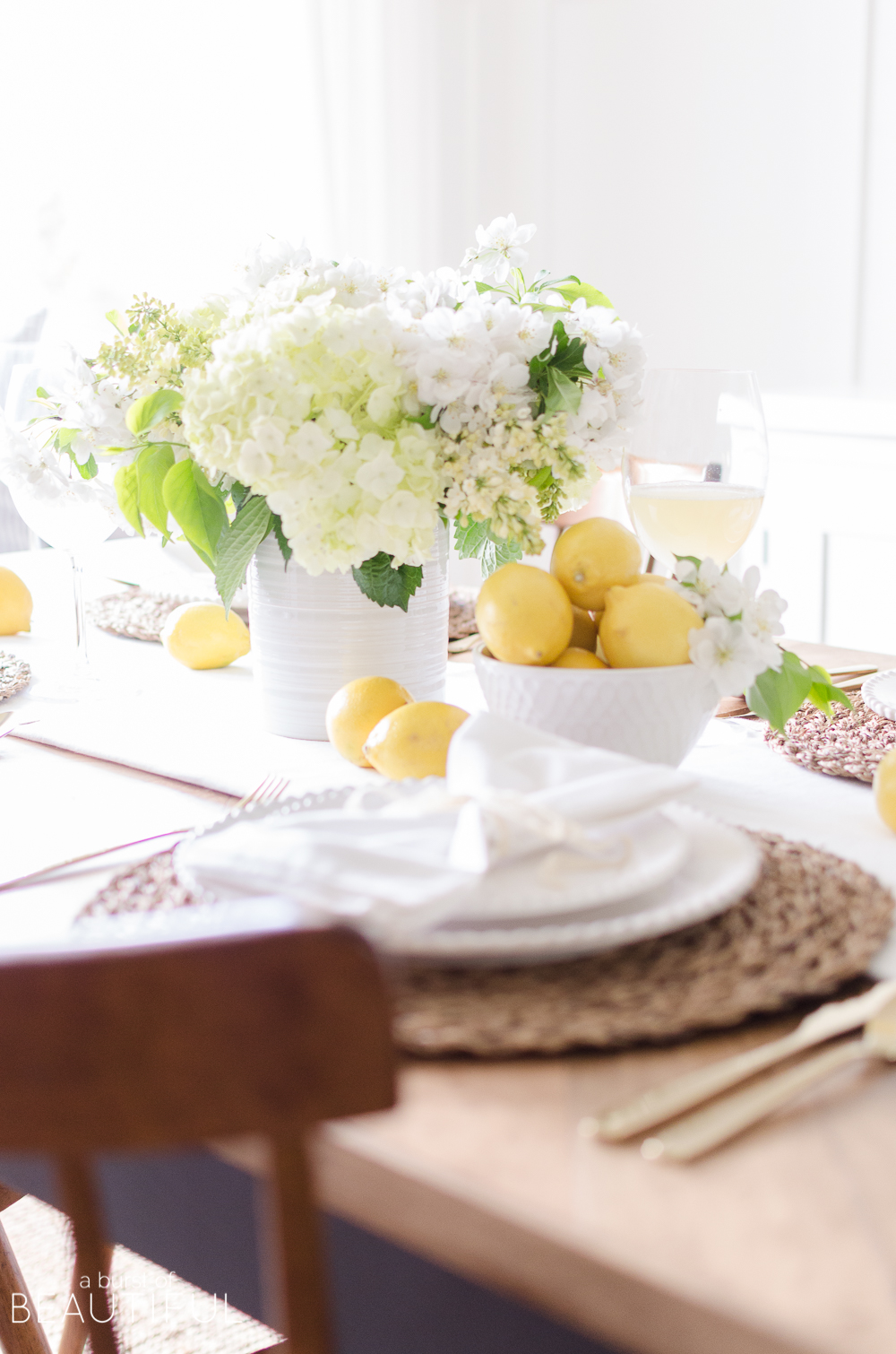 Summer entertaining is easy when you set this cheerful white and yellow summer tablescape using fresh flowers and fruit. 