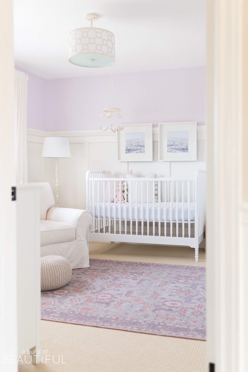 Soft shades of lavender and rose mixed with whimsical details bring this sweet and colorful nursery to life.