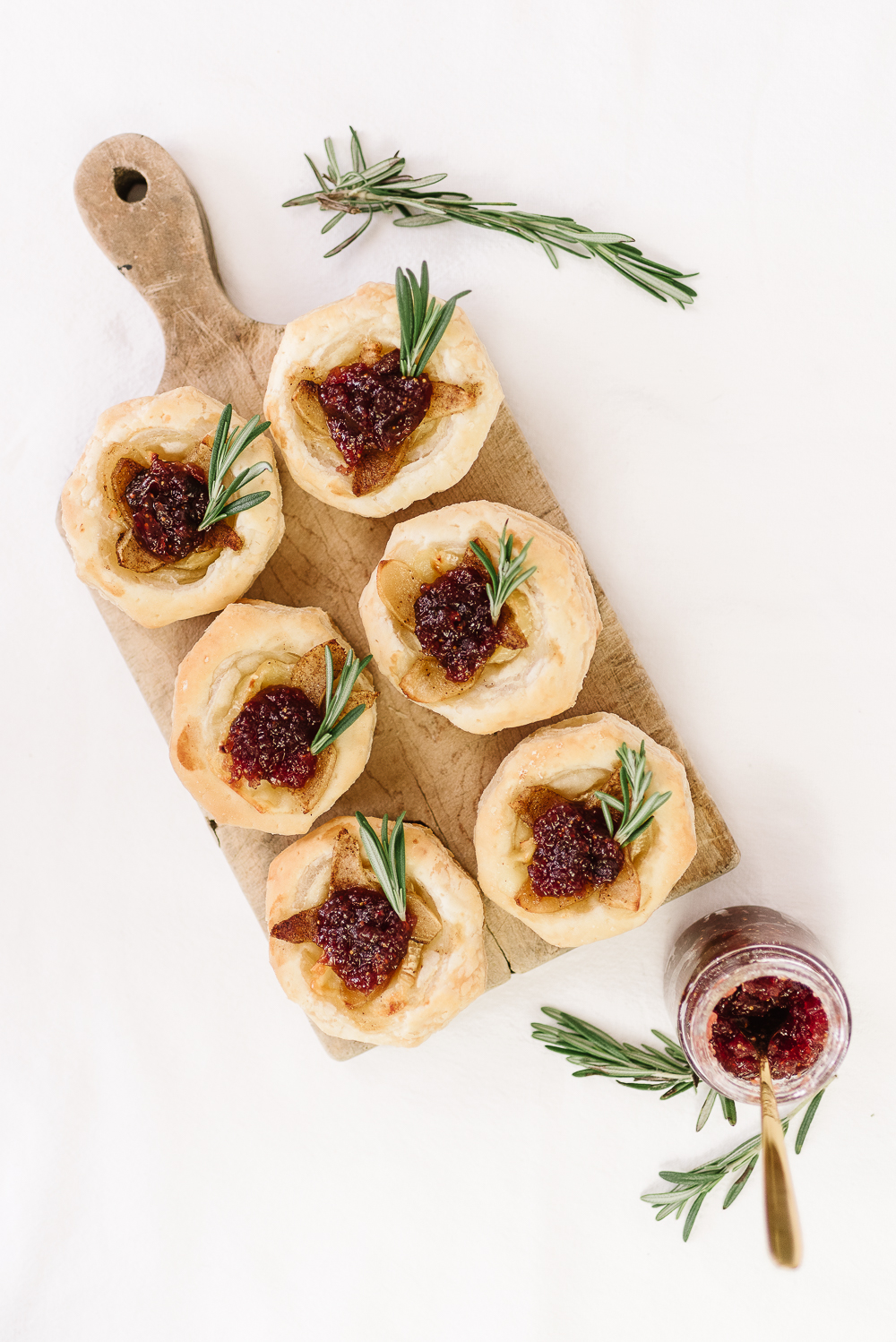 puff pastry shell brie and roasted pear tartlets on cutting board